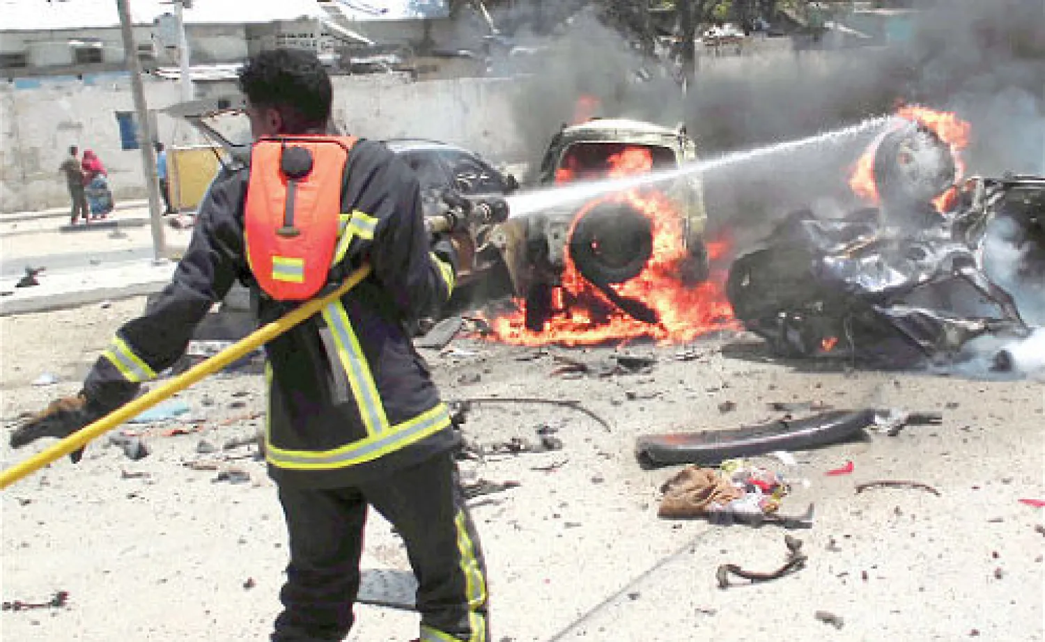 اطفائي يحاول اخماد النيران التي اندلعت اثر انفجار سيارة مفخخة في مقديشيو أمس (إ. ب. أ)