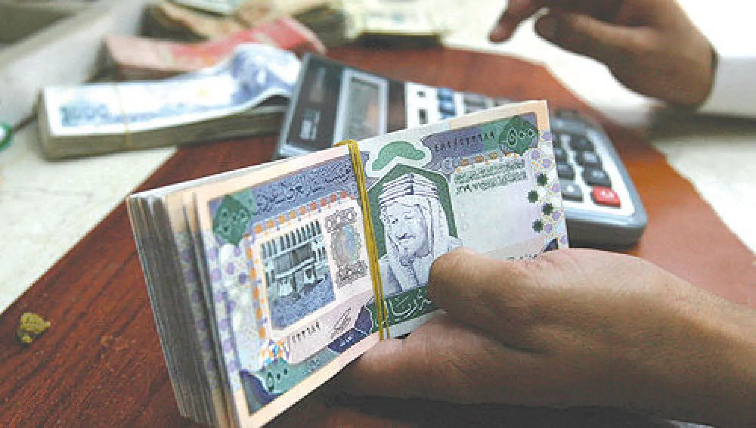 موظف يعد أوراقا مالية سعودية («الشرق الأوسط»)
