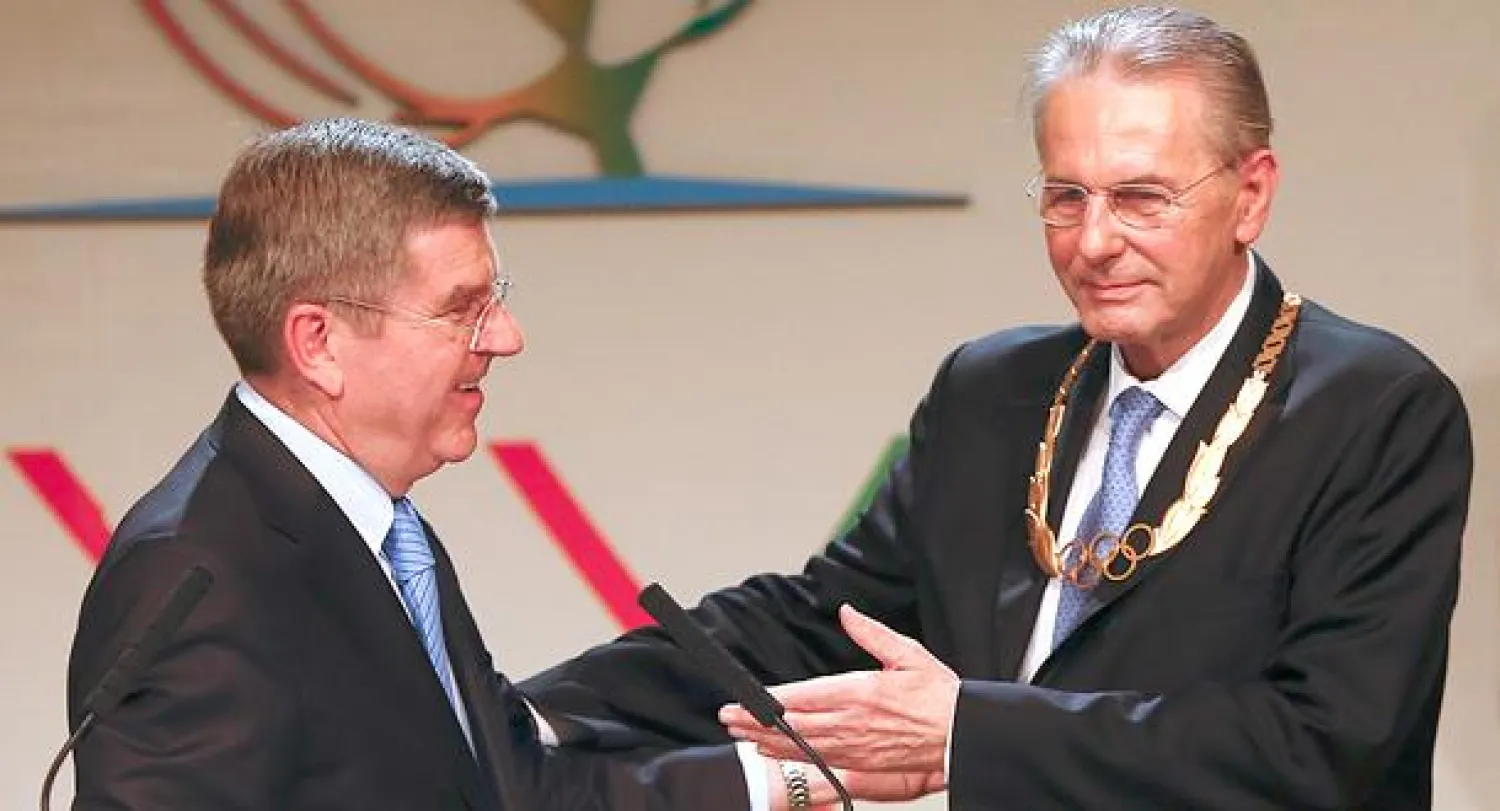 روغ (يمين) يقدم خلفه باخ الفائز برئاسة اللجنة الأولمبية الدولية