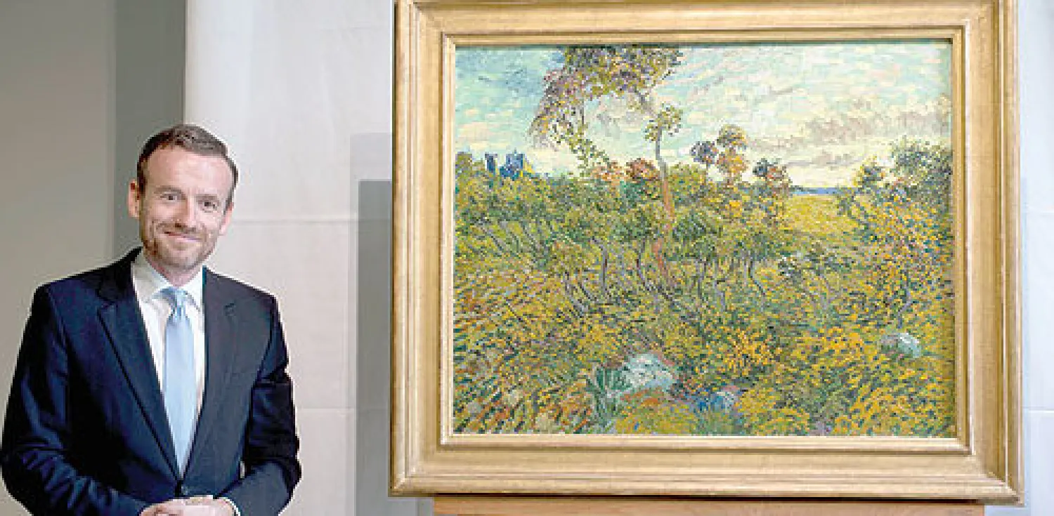 أكسل روغر مدير متحف فان غوخ بأمستردام إلى جانب اللوحة المكتشفة (أ.ب)