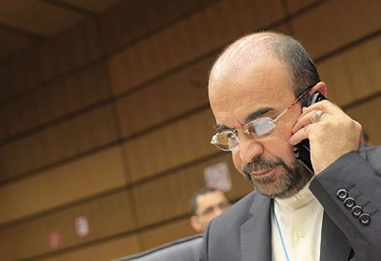 رضا النجفي سفير إيران لدى الوكالة الدولية للطاقة الذرية يجري مكالمة هاتفية خلال اجتماع جرى أمس بمقر المنظمة في فيينا (أ.ف.ب)