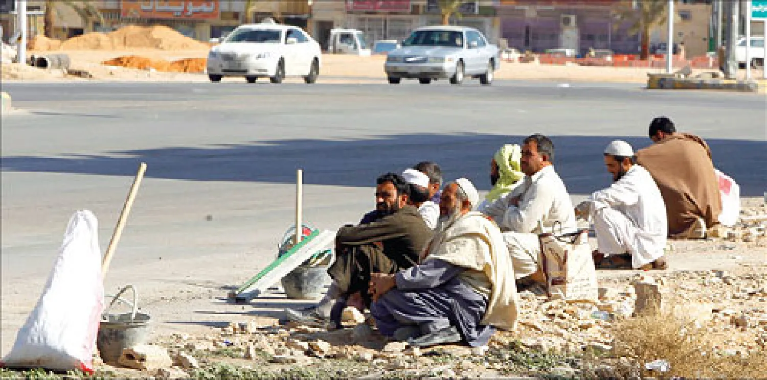عدد من العمالة الوافدة في أحد شوارع العاصمة الرياض، تعرض خدماتها للأشغال اليومية الخفيفة. (رويترز)