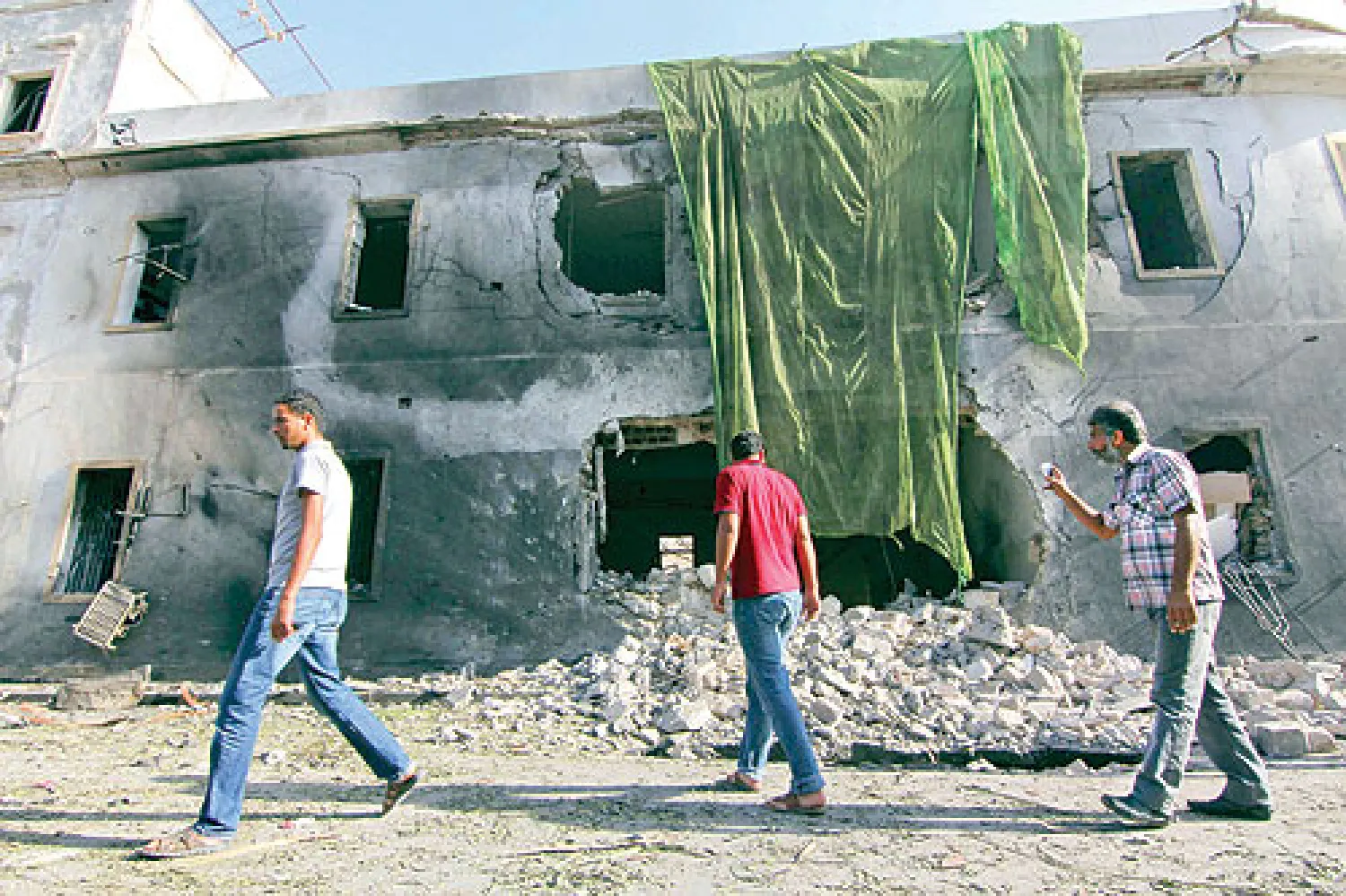 ليبيون يتجمعون أمام فرع وزارة الخارجية في بنغازي عقب استهدافها أمس بسيارة مفخخة (أ.ب)