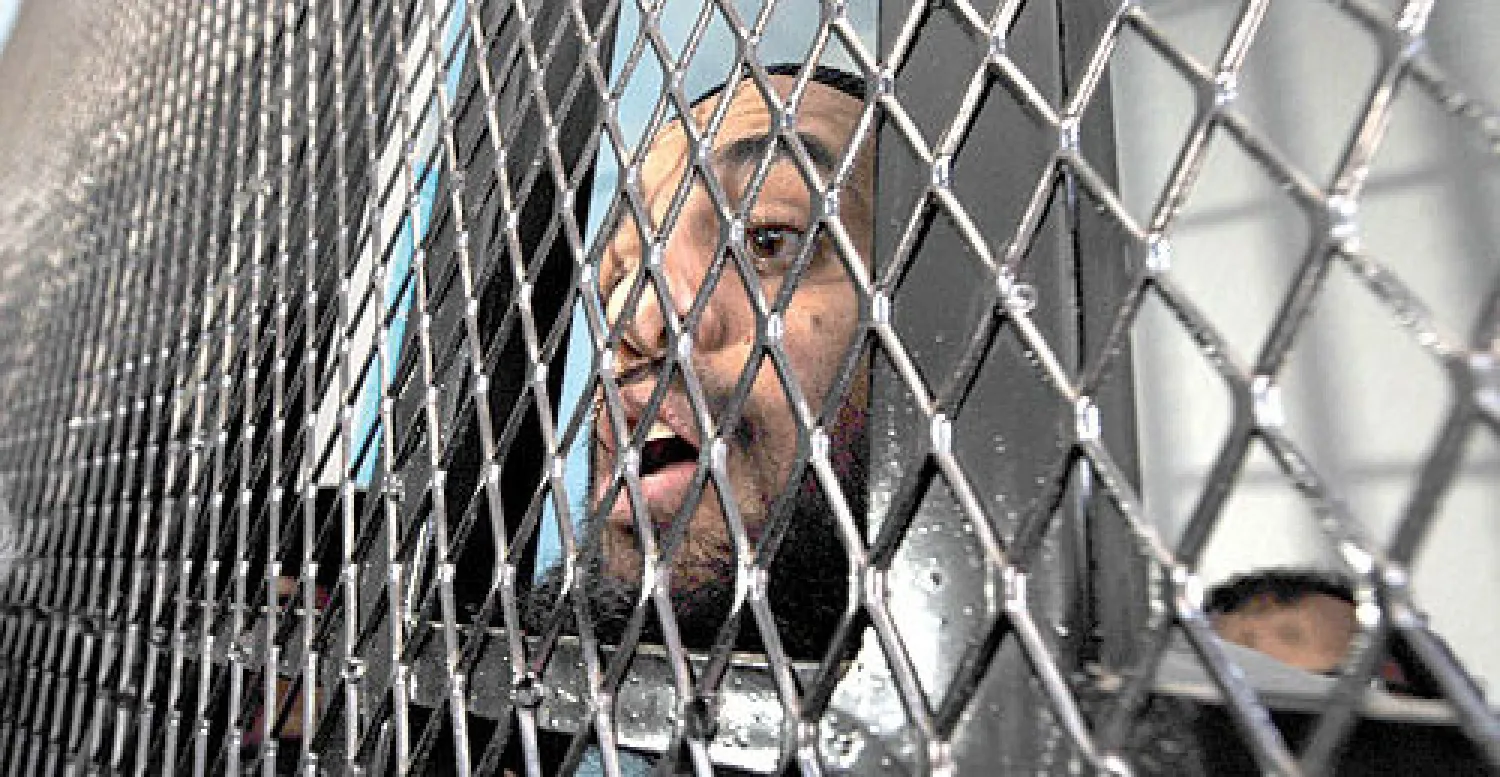 عبد الرحمن الشهري يصرخ من وراء القضبان أثناء محاكمته بتهمة الانتماء للقاعدة في محكمة الأمن القومي بصنعاء أمس (إ.ب.إ)