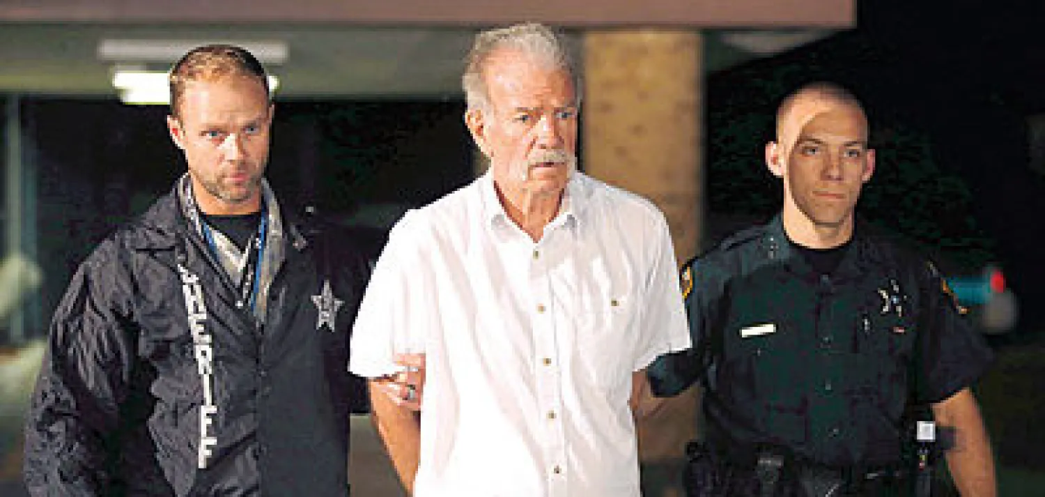 ضابطا شرطة أثناء اعتقالهما القس تيري جونز في فلوريدا مساء أول من أمس (أ.ب)