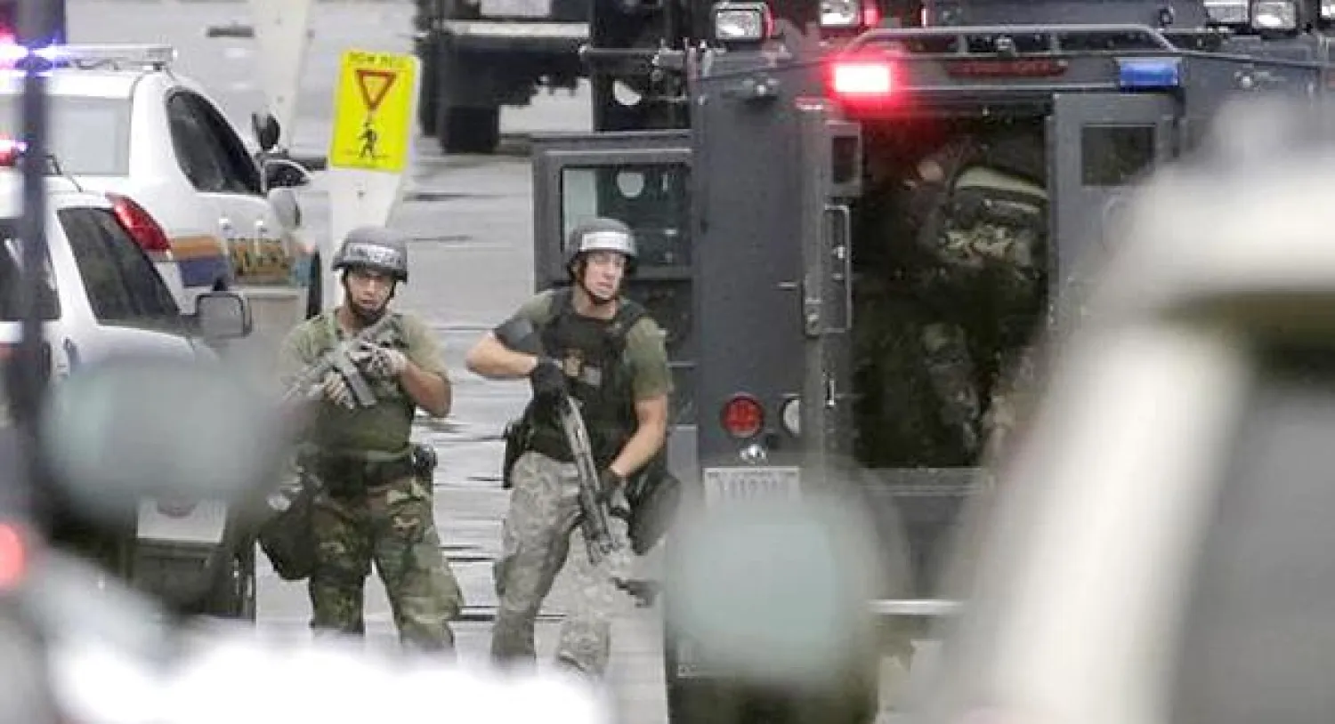 افراد من قوات الأمن الأميركية أثناء عملية تطهير مبنى البحرية الأميركية بعد إطلاق النار اليوم (رويترز)