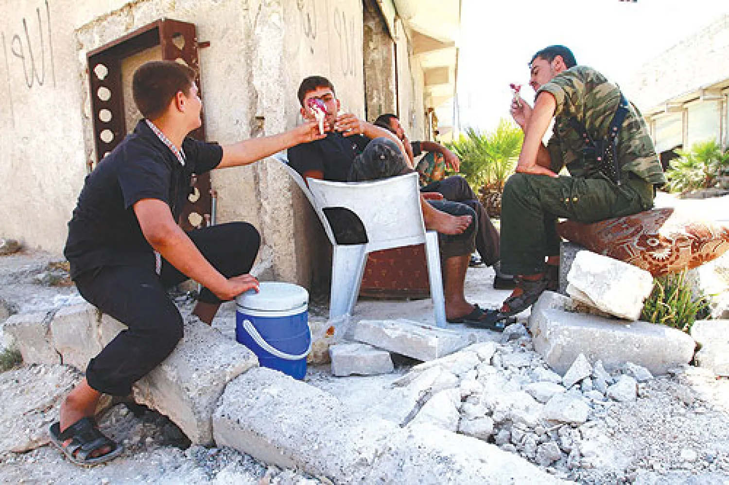 مقاتلون في الجيش السوري الحر يشترون المرطبات من بائع متجول في حلب أمس (رويترز)