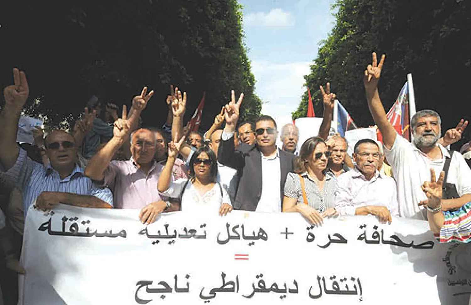 رئيسة نقابة الصحافيين التونسيين نجيبة حمروني (وسط) أثناء مشاركتها في مظاهرة في تونس احتجاجا على محاكمة اعلاميين (أ.ف.ب)