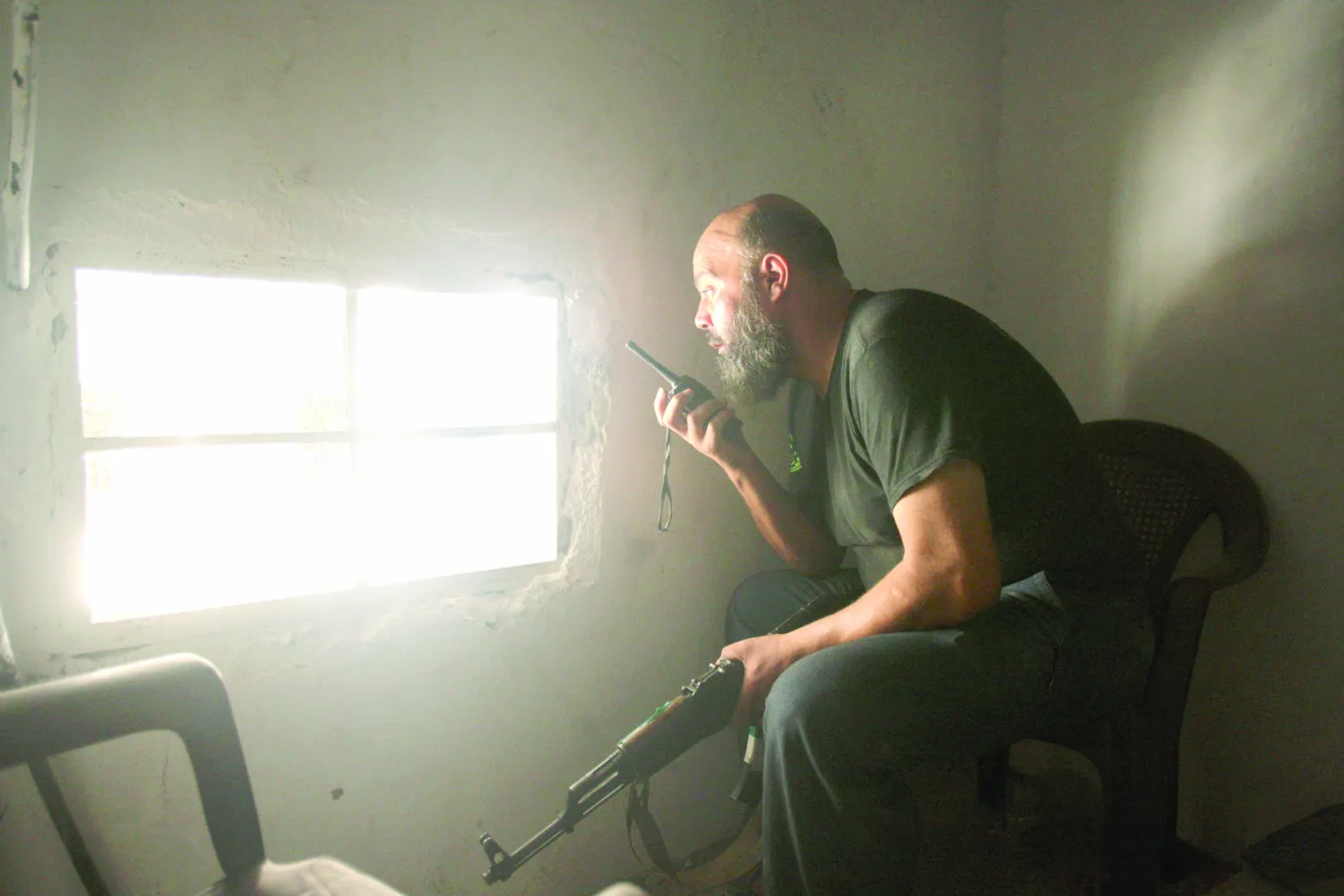 مقاتل من الجيش السوري الحر يتحدث في جهاز الـ«ووكي- توكي» في حي صلاح الدين بحلب أمس (رويترز)  