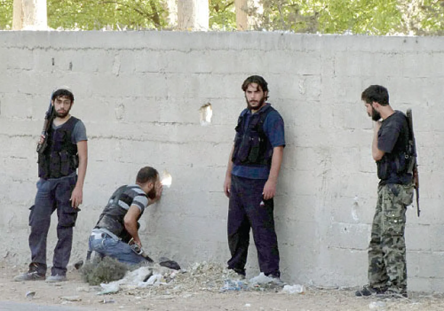 مقاتلون من الجيش السوري الحر خلال اشتباكات في منطقة الجسر الخامس بطريق مطار دمشق الدولي أمس (رويترز)