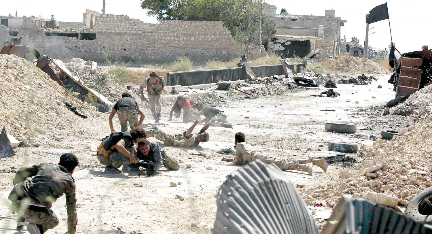 مقاتلون في «الجيش السوري الحر» يزحفون أرضا بعد تعرضهم لنيران قناصة في حي الشيخ سعيد بحلب أمس (رويترز)