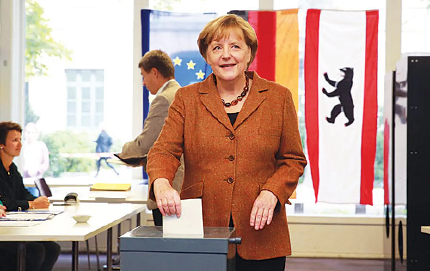 المستشارة الألمانية أنجيلا ميركل تدلي بصوتها في مقر انتخابي بوسط برلين أمس (إ.ب.أ)