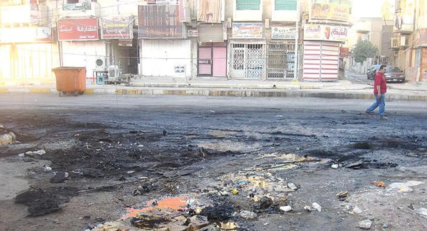 عراقي يسير أمس في موقع انفجار استهدف مجلس عزاء  في حي الأعظمية ببغداد أول من أمس (رويترز)