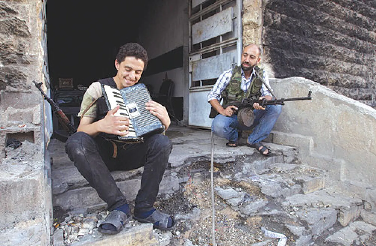 مقاتل في «الجيش الحر» يعزف على آلة الأكورديون في حي سيف الدلة بحلب (رويترز)