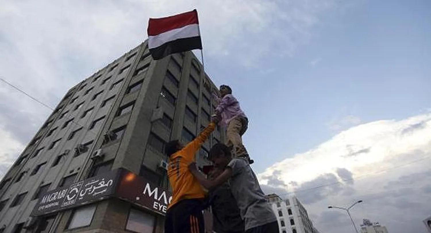 يمنيون يرفعون علم بلادهم اليوم في الذكرى الثانية للمواجهات الدامية التي  نشبت في صنعاء بين معارضي الرئيس اليمني السابق علي عبد الله صالح وقوات الامن (رويترز)