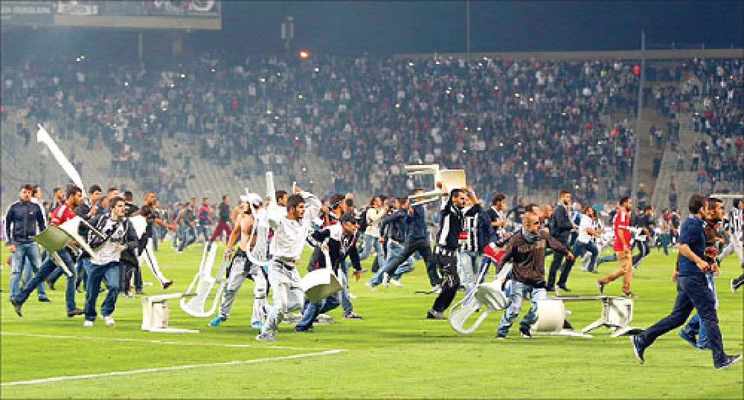 جماهير بشيكتاش تغزو الملعب بالكراسي والعصي لإفساد لقاء القمة أمام غلاطة سراي (رويترز)