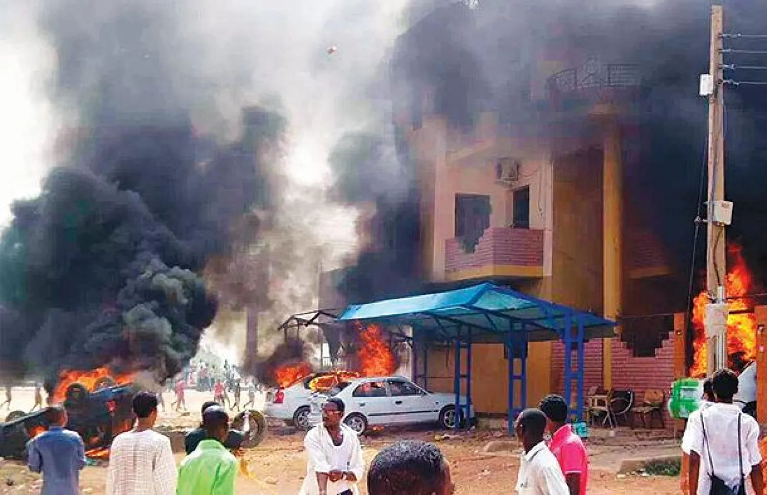 حرائق للسيارات بالقرب من أحد المباني بالعاصمة السودانية الخرطوم (رويترز)