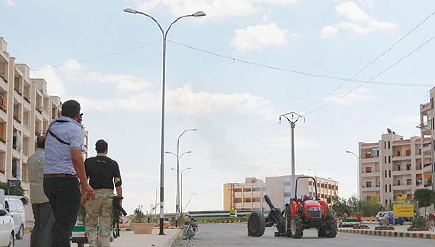 مقاتلون في الجيش السوري الحر بعد إطلاقهم صاروخا بدائي الصنع في حي الأشرفية بحلب أمس (رويترز)