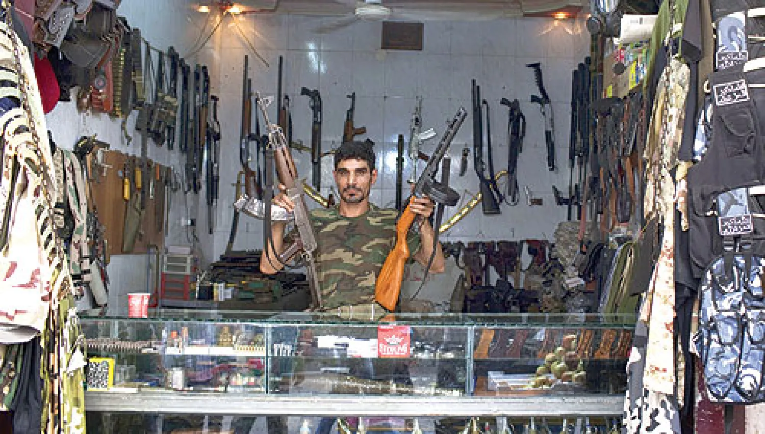 أبو محمد يبيع في متجره أيضا ألبسة عسكرية وأقنعة واقية من الغاز وأجهزة اتصال لاسلكية (أ.ف.ب)