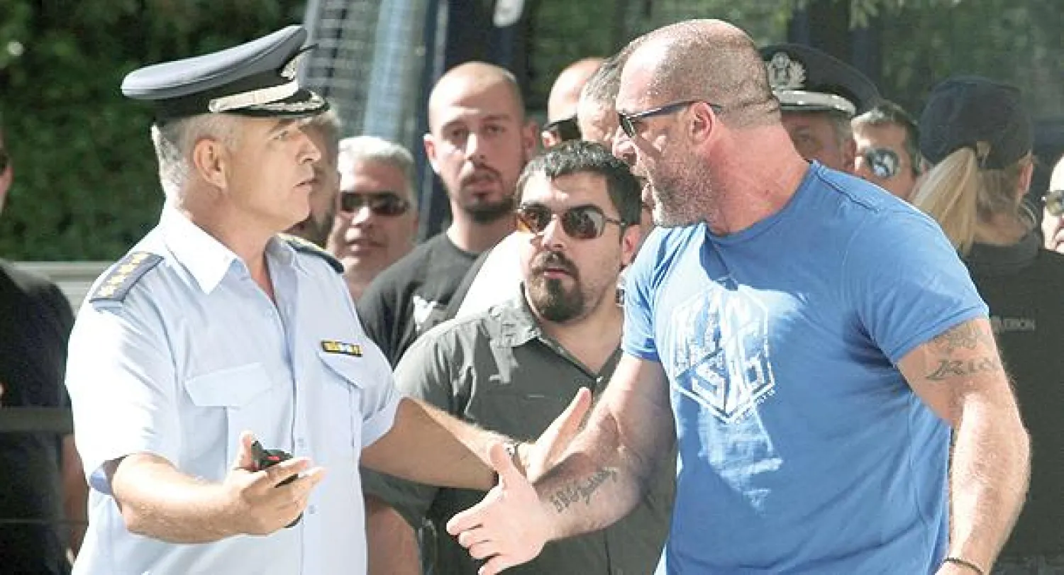 توقيف زعيم حزب «الفجر الذهبي» نيكوس ميخالولياكوس (يمين) في أثينا أمس (إ.ب.أ)