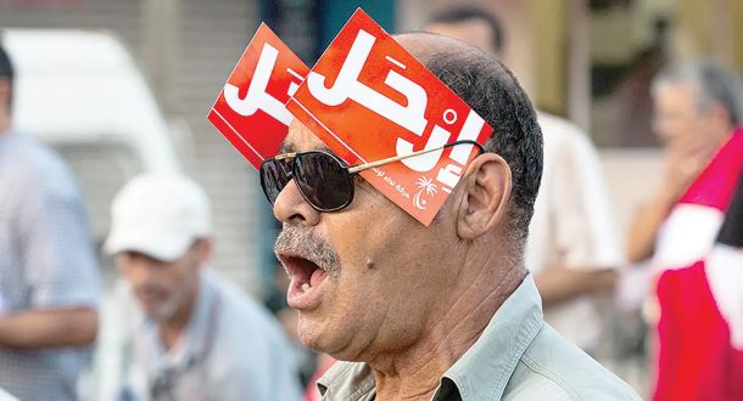 تونسيون يتظاهرون ضد حكومة النهضة الإسلامية أمام مقرها في العاصمة تونس أمس (أ.ب)