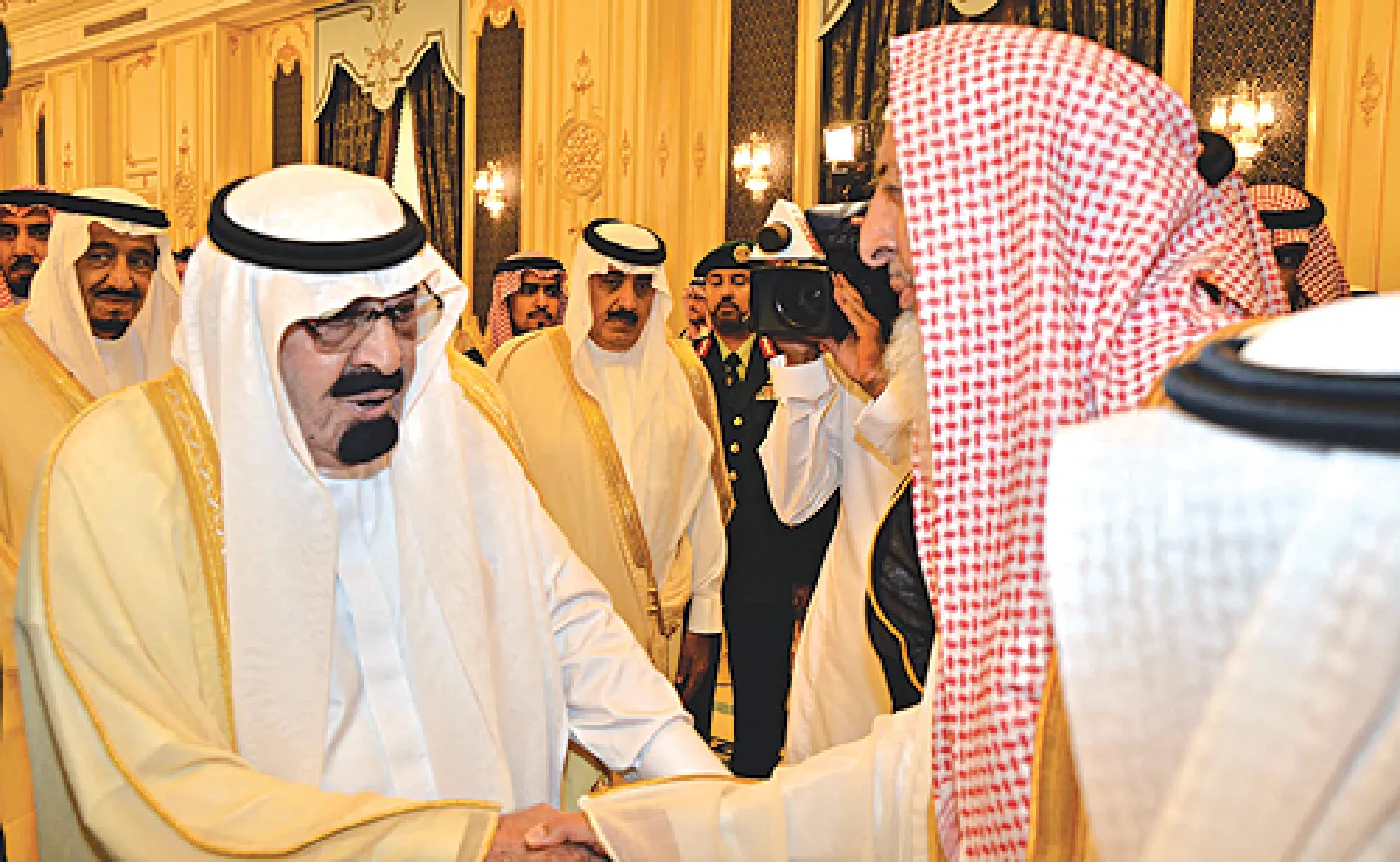 خادم الحرمين مصافحا مفتي عام السعودية ضمن استقباله للعلماء وكبار مسؤولي الدولة في قصر السلام بجدة أمس  ويبدو الأمير سلمان بن عبد العزيز ولي العهد والأمير متعب بن عبد الله (واس)