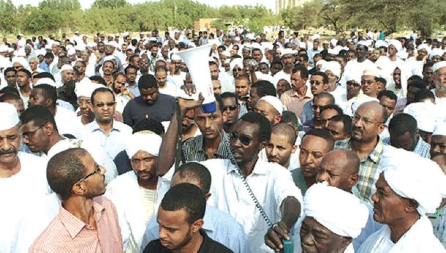 أصدقاء وأقارب صلاح مدثر الذي قتل في اشتباكات الخرطوم أول من أمس يمشون في جنازته ويطلقون الشعارات ضد الحكومة (أ.ف.ب)