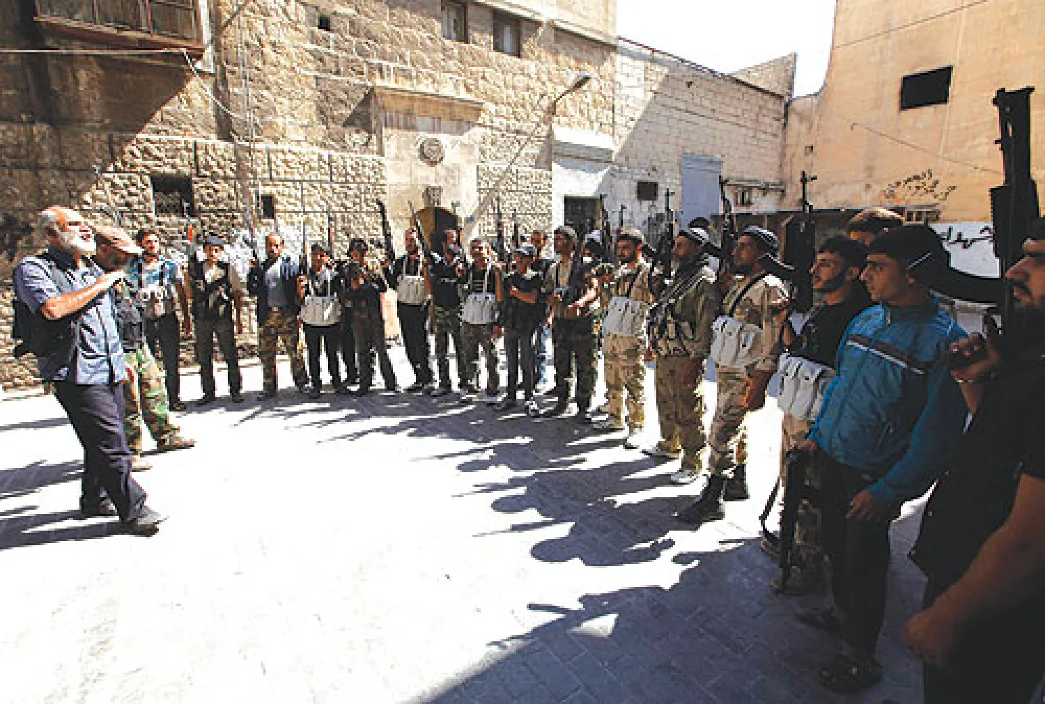 قيادي في الجيش الحر يتحدث إلى مقاتلين قرب قصر العدالة في حلب أمس (رويترز)