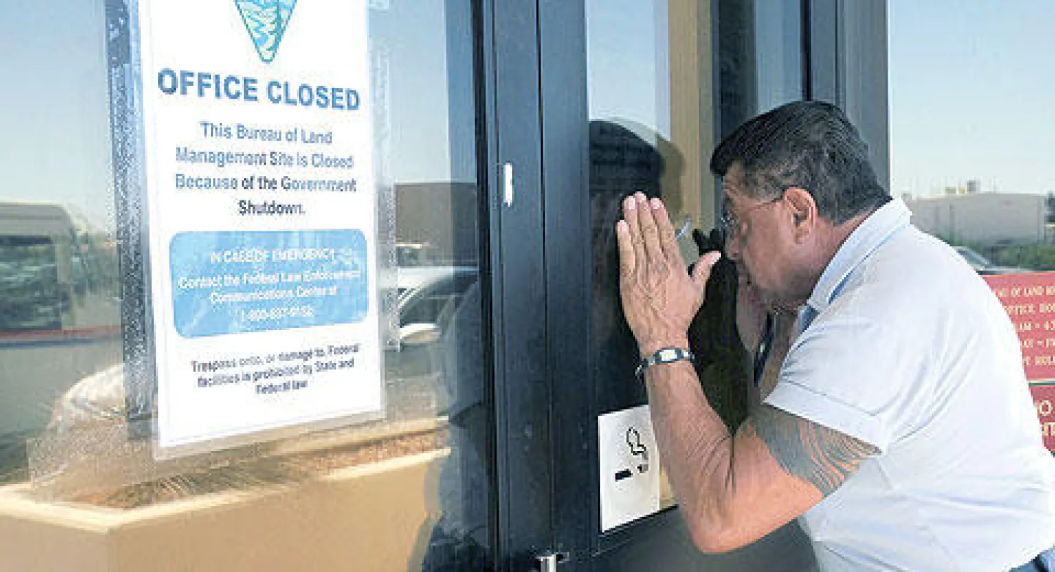 أميركي ينظر عبر نافذة مكتب للبريد جرى إغلاقه بسبب شلل الميزانية  في مدينة لاس كروسيس بولاية نيو مكسيكو أمس (أ.ب)