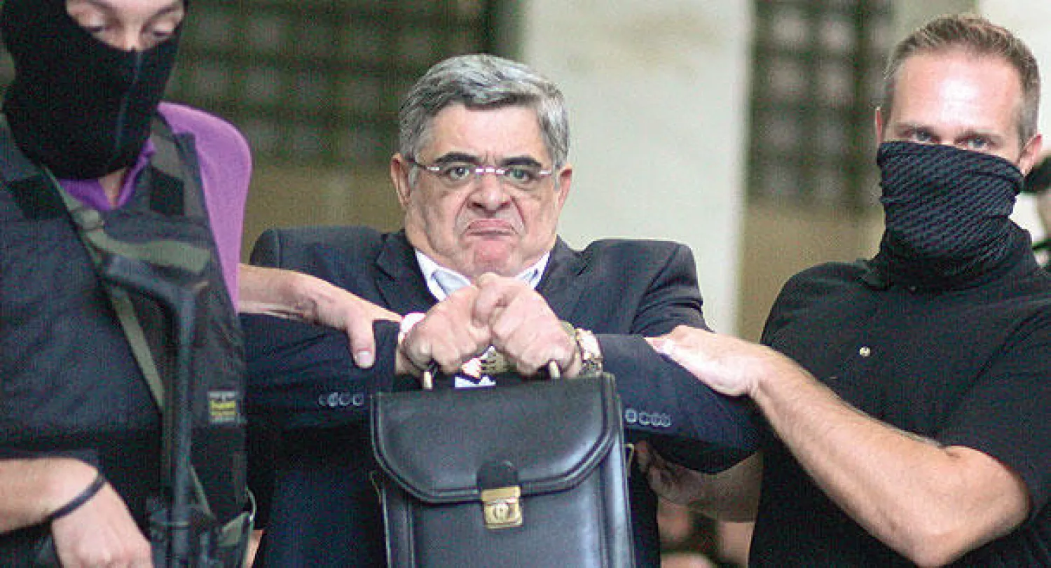 شرطة مكافحة الإرهاب تعتقل زعيم حزب الفجر الذهبي نيكوس ميخالولياكوس في أثينا أمس (أ.ب)