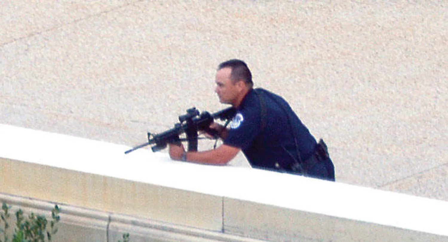 رجل شرطة يتأهب بعد سماع إطلاق نار أمام مقر الكونغرس في واشنطن أمس (أ.ف.ب)