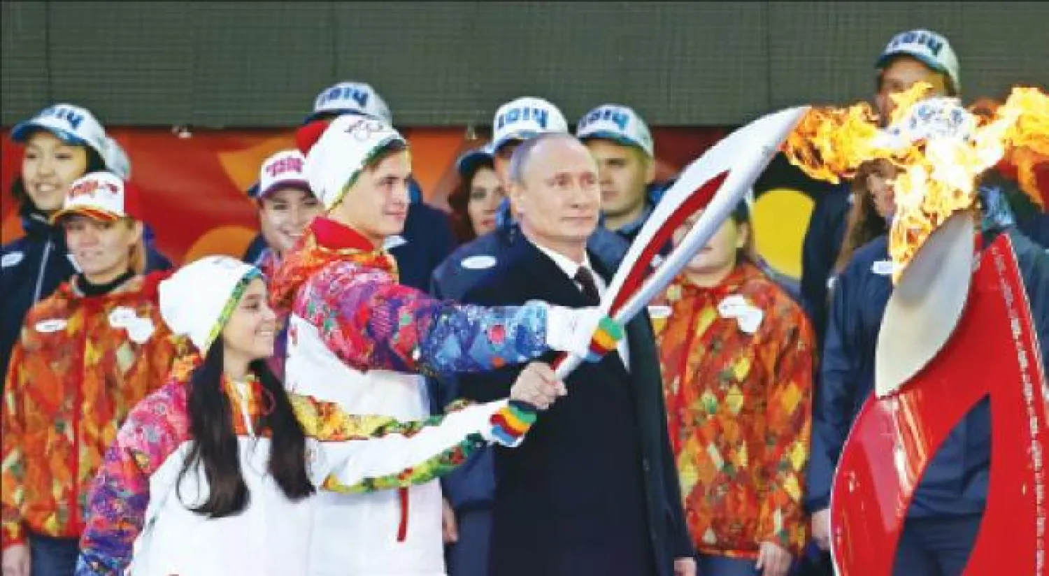 الرئيس الروسي فلاديمير بوتين يحمل الشعلة  في الساحة الحمراء في موسكو أمس (إ.ب.أ)