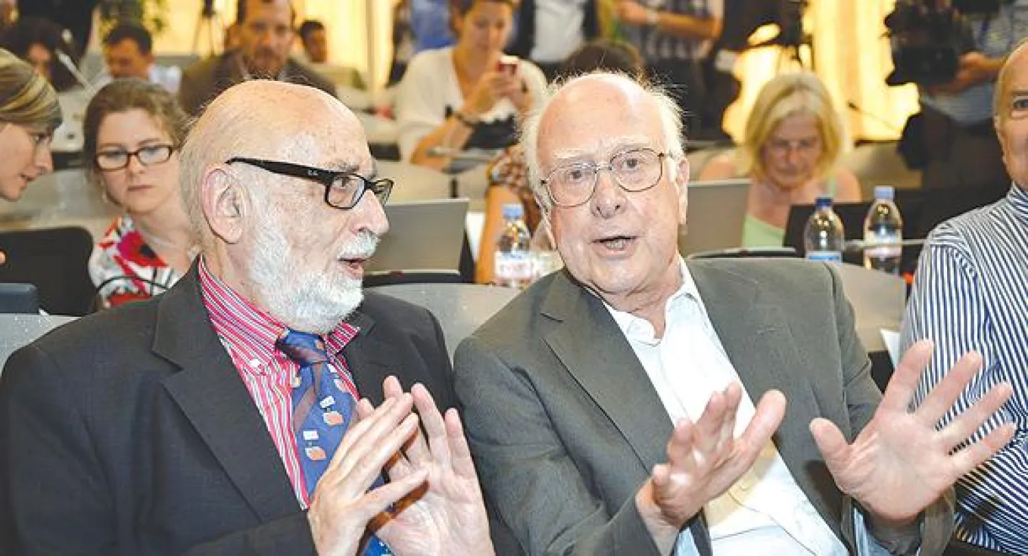 البلجيكي فرنسوا إنغليرت والبريطاني بيتر هيغز (يمين) خلال مؤتمر للمركز الأوروبي للبحث النووي (سيرن) في جنيف بسويسرا (أ.ب)