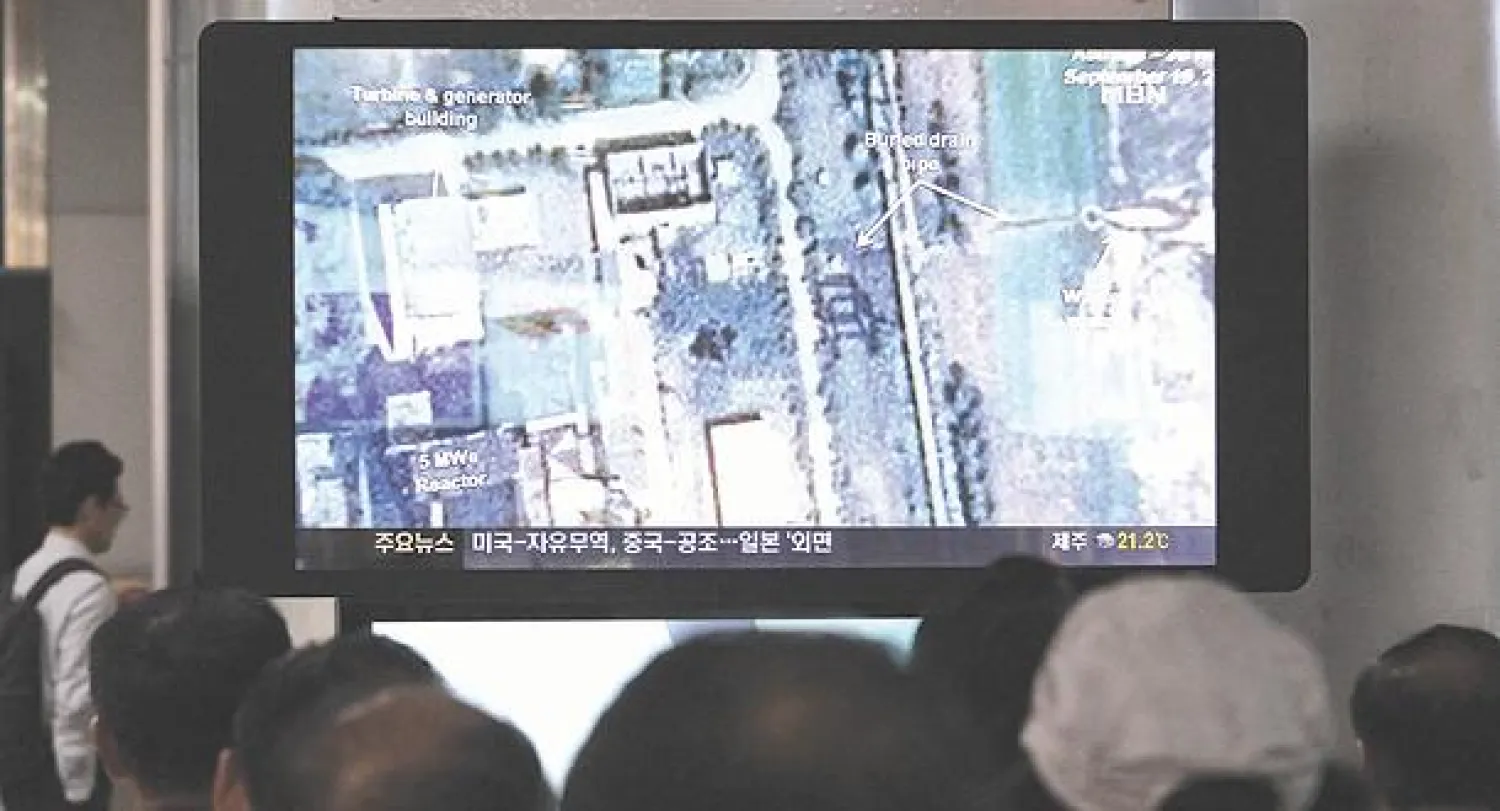 كوريون جنوبيون يتابعون على شاشة تلفزيون كبيرة في محطة قطار سيول أنباء حول مفاعل نووي في كوريا الشمالية (أ.ب)