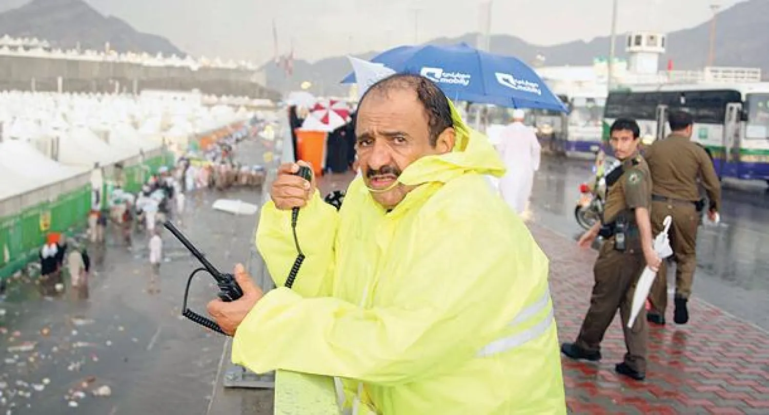 الفريق سعد التويجري ممسكا بجهاز إرسال وقت هطول الأمطار في موسم سابق للحج (تصوير: خضر الزهراني)