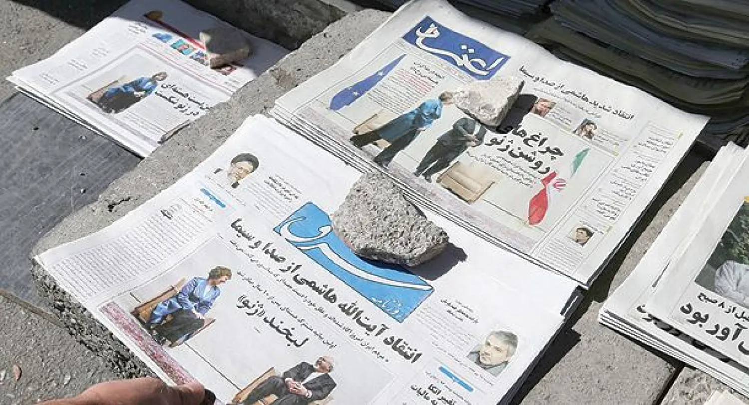 صحف ايرانية معروضة على الارض خارج كشك في طهران أمس تعرض على صفحاتها الاولى المحادثات النووية في جنيف بين ايران والغرب. (أ.ف.ب)