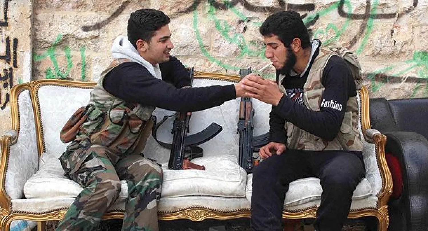 مقاتلان من الجيش الحر يأخذان قسطا من الراحة في مدينة حلب أمس (رويترز)