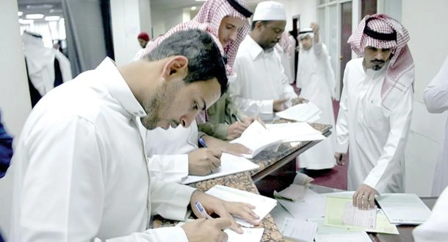 عملاء يجرون معاملاتهم داخل أحد أفرع البنوك المحلية في الرياض («الشرق الأوسط»)