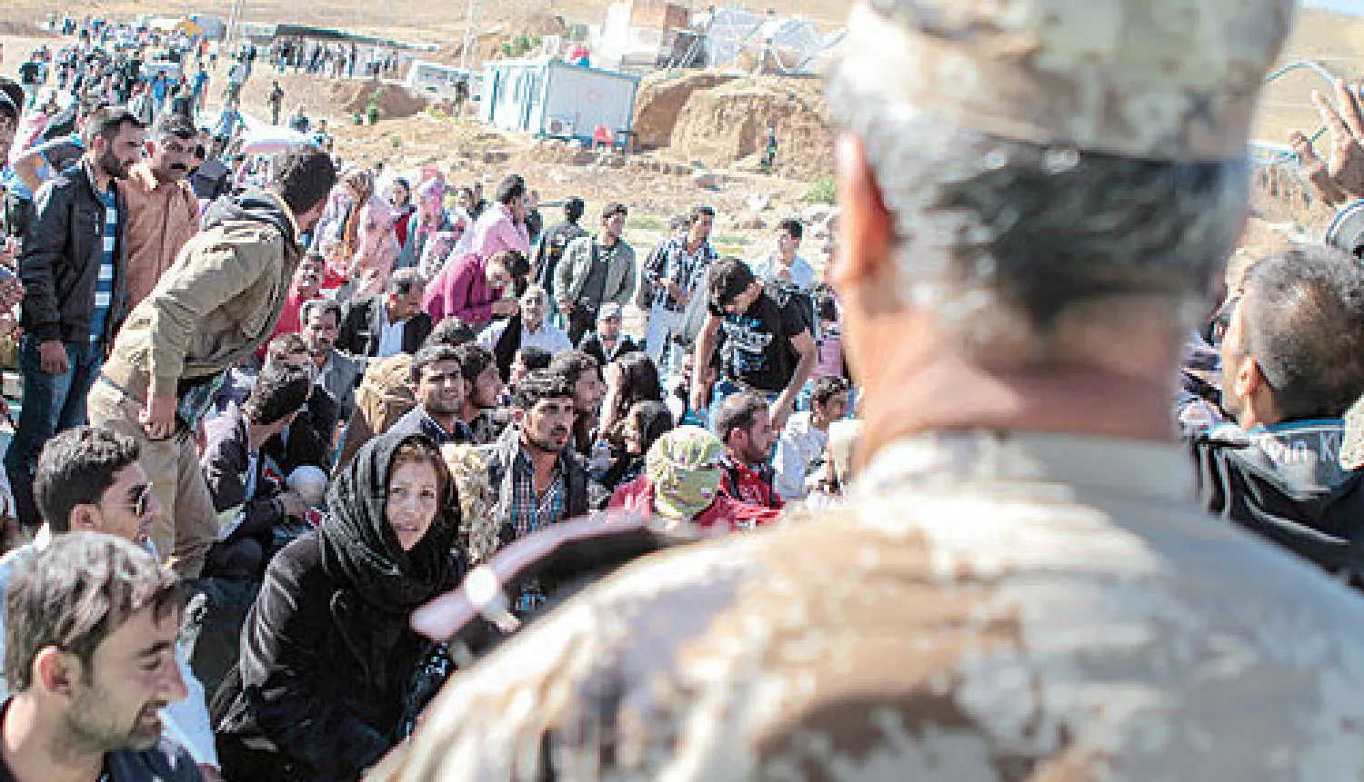 سوريون يتجمعون عند الحدود العراقية من جهة إقليم كردستان في انتظار فتح الأبواب لهم للعبور إلى محافظة دهوك (أ.ف.ب)