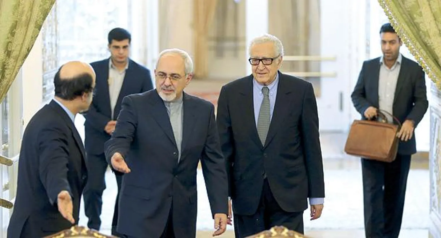 وزير الخارجية الإيراني جواد ظريف ومبعوث الأمم المتحدة الأخضر الإبراهيمي لدى وصولهما إلى مؤتمر صحافي عقداه في طهران أمس (أ.ب)