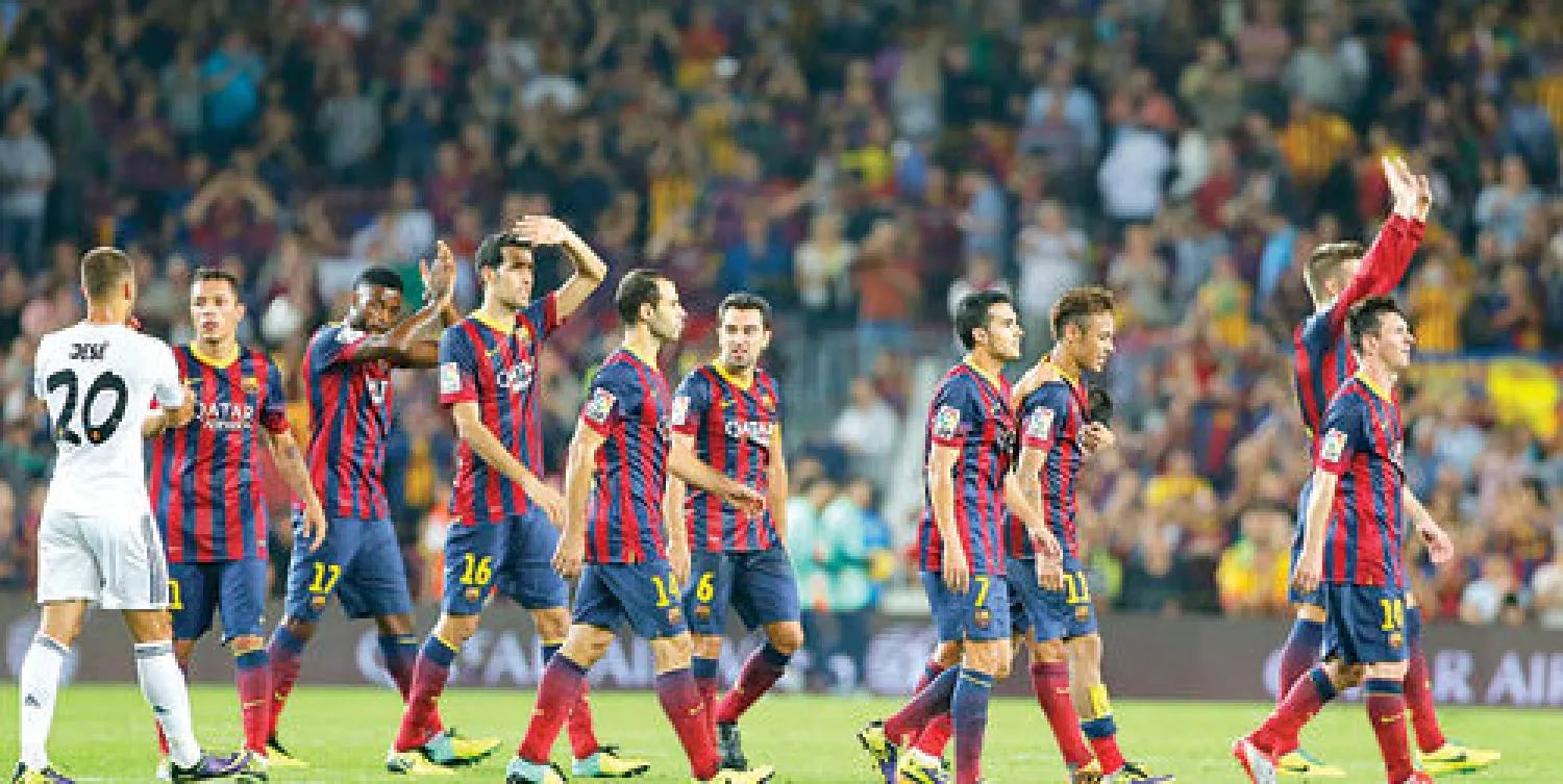 أفراح لاعبي برشلونة وجماهيرهم بعد حسم القمة الإسبانية (أ.ب)