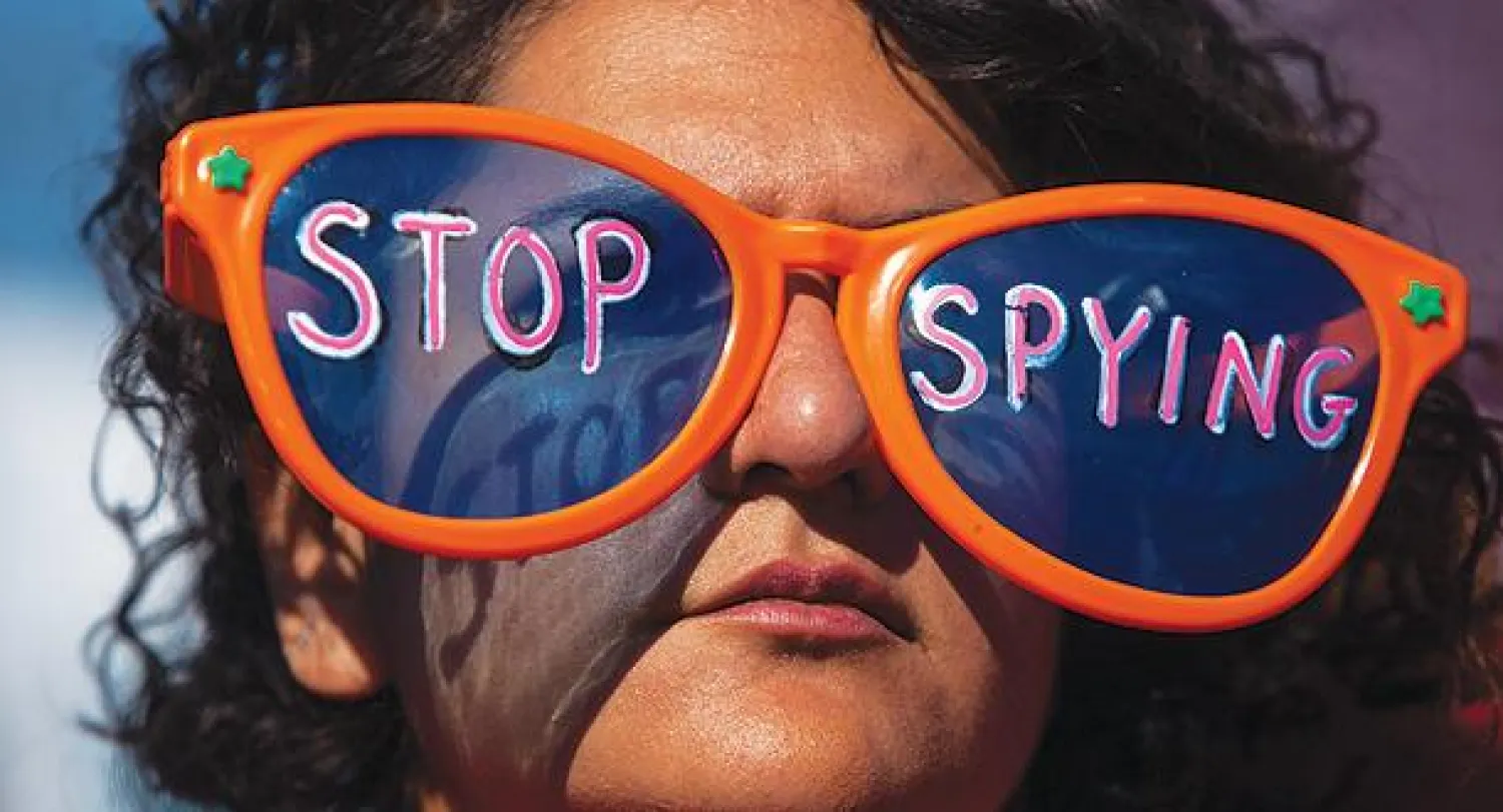 سيدة أميركية ترتدي نظارة كتب عليها «توقفوا عن التجسس» خلال مظاهرة ضد برامج التنصت الأميركي شارك فيها المئات أمام البيت الأبيض أمس (أ.ف.ب)