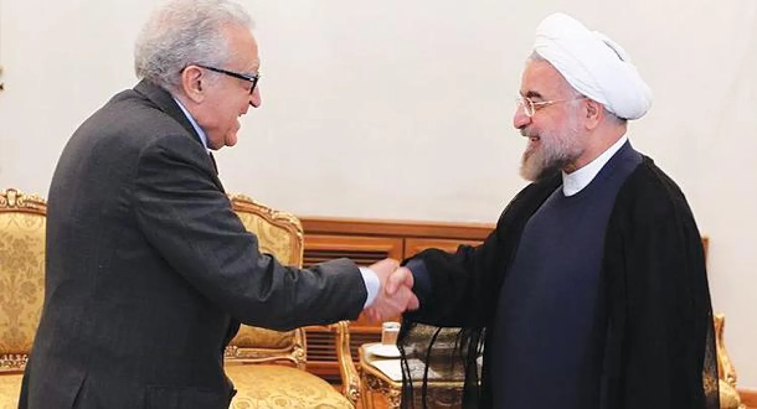 الرئيس الإيراني حسن روحاني لدى استقباله المبعوث الدولي إلى سوريا الأخضر الابراهيمي في طهران أمس (إ.ب.أ)