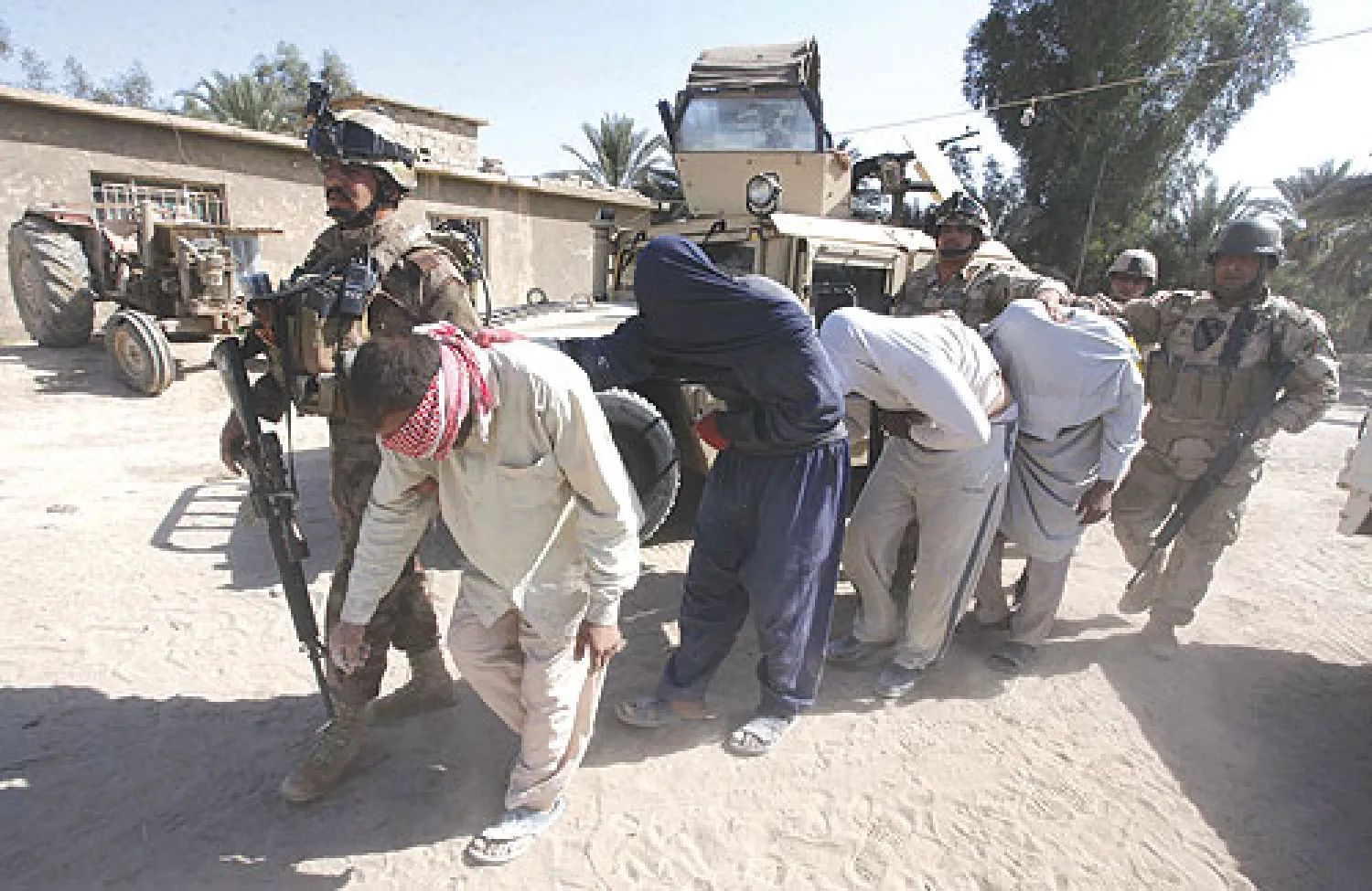 جنود عراقيون يقتادون مسلحين مشتبها فيهم اعتقلوا خلال مداهمة شمال محافظة بابل أول من أمس (رويترز)