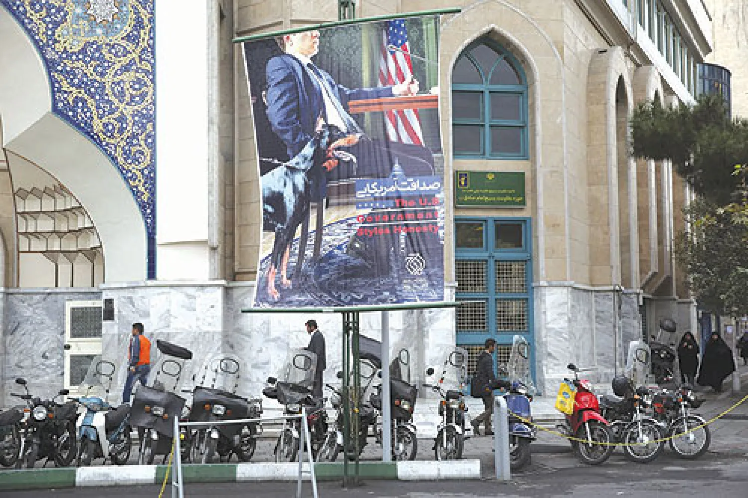 لافتة في ميدان فلسطين بطهران تظهر مفاوضا أميركيا وبجانبه كلب يرمز للتهديد المصاحب للمفاوضات (أ.ب)