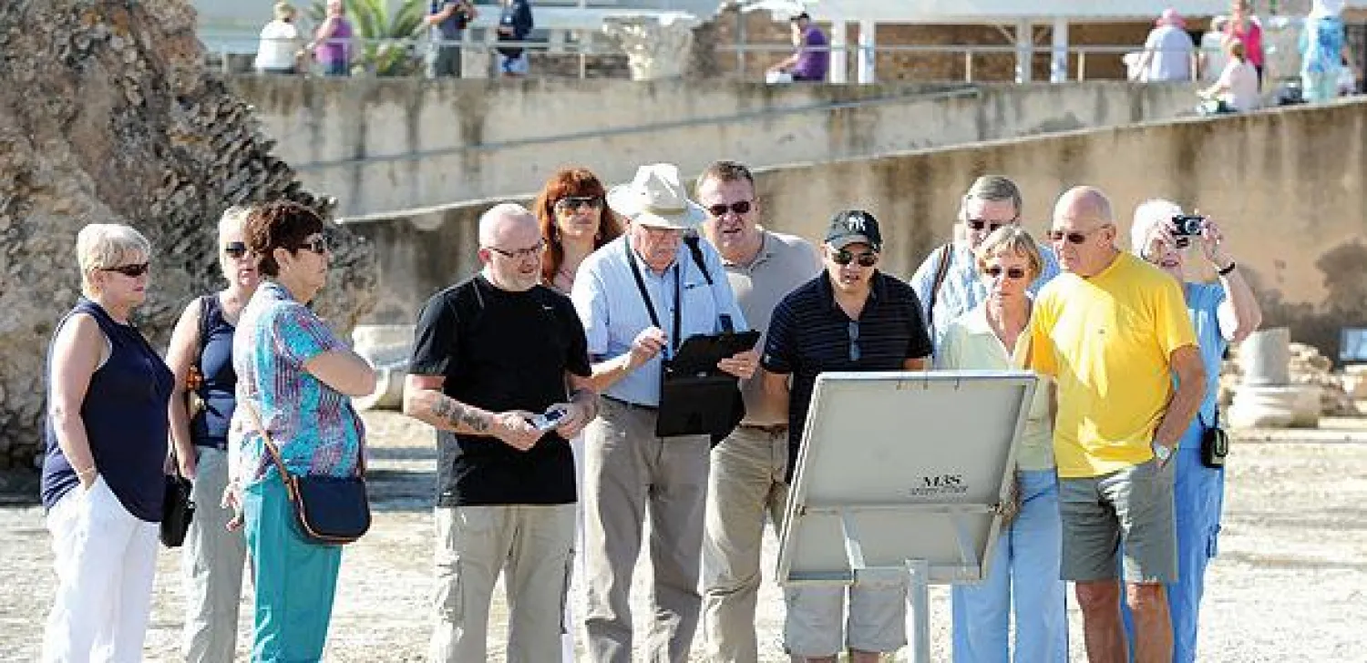 مجموعة من السياح يزورون ضاحية قرطاج الأثرية القريبة من تونس العاصمة بعد يوم  من التفجير الانتحاري الذي وقع أمس (أ.ف.ب)