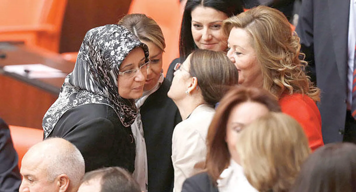 النائبة كولاي صامنجي، عضو البرلمان التركي عن الحزب الحاكم، تتلقى التهاني من زميلاتها لدخولها البرلمان محجبة (رويترز)