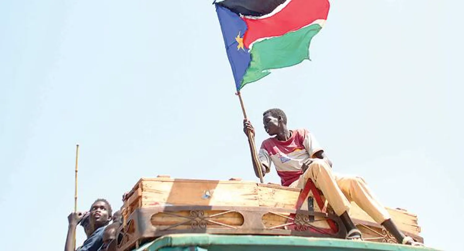 مواطن من دولة جنوب السودان يرفع علم بلاده أمس احتفالا بنتيجة الاستفتاء بضم منطقة أبيي (رويترز)