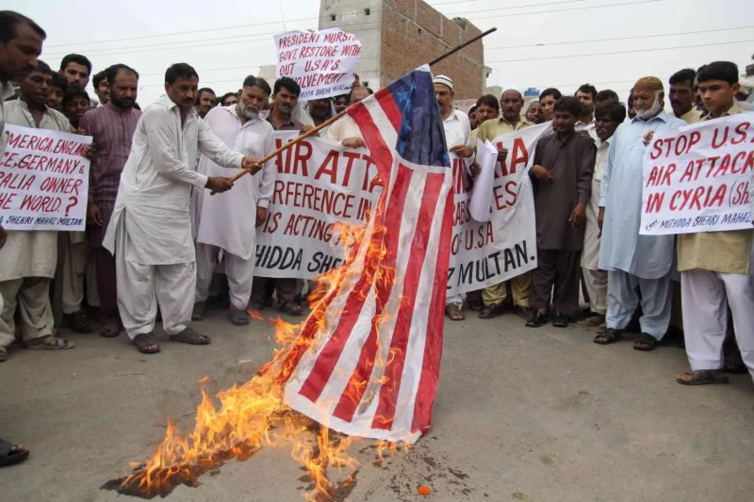 باكستانيون في مظاهرات خرجت الشهر الماضي يحرقون العلم الأميركي احتجاجا على الغارات الأميركية على أراضيهم (أ.ف.ب)