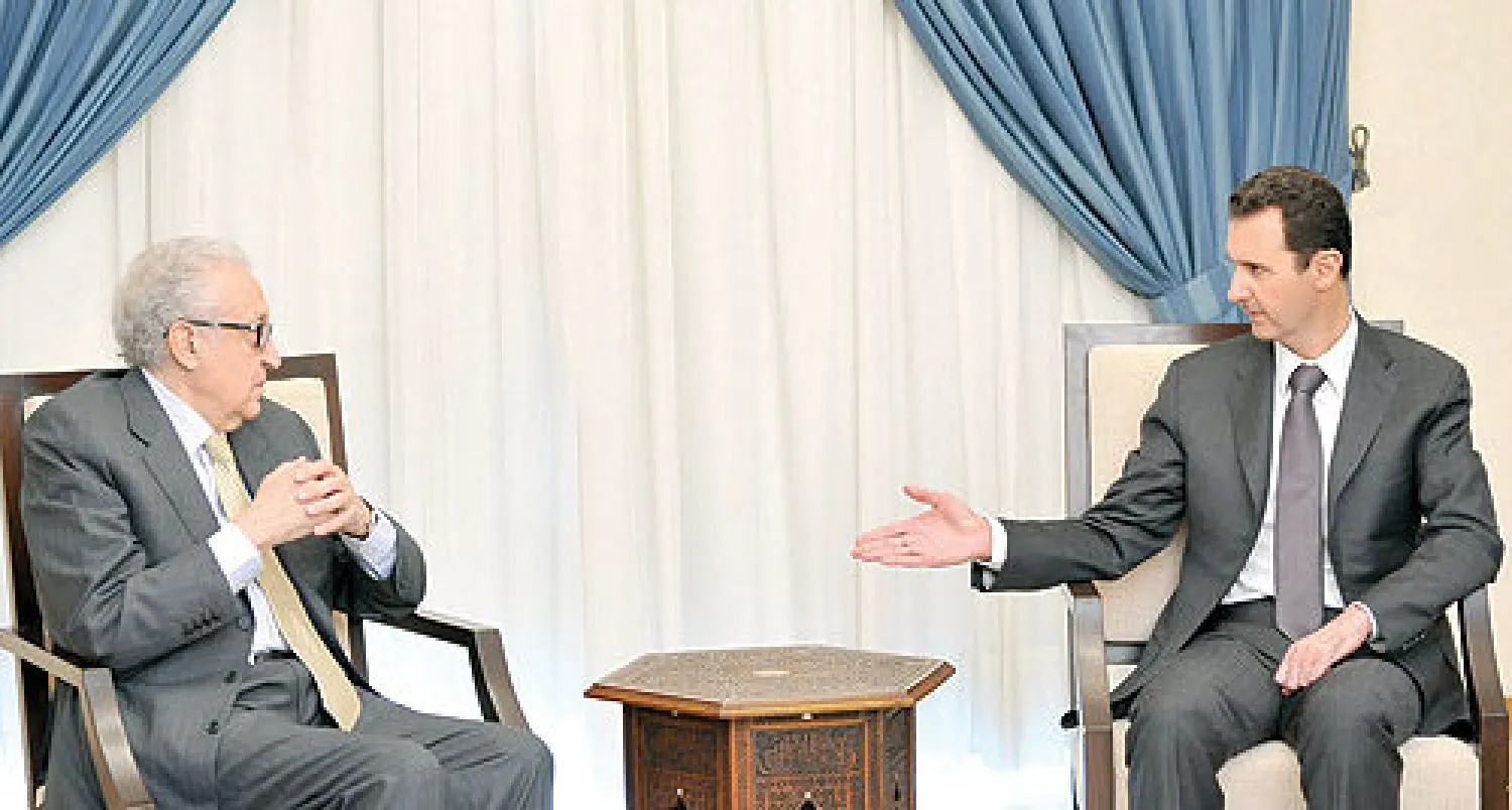 الرئيس السوري بشار الأسد يتحدث إلى المبعوث الدولي الأخضر الإبراهيمي لدى لقائهما في دمشق أمس (أ.ب)